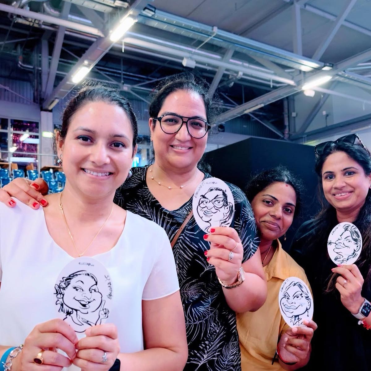 Vier Frauen zeigen ihre auf Bierdeckeln von Arnd Hawlina erstellten Karikaturen Vier Frauen zeigen ihre auf Bierdeckeln von Arnd Hawlina erstellten Karikaturen